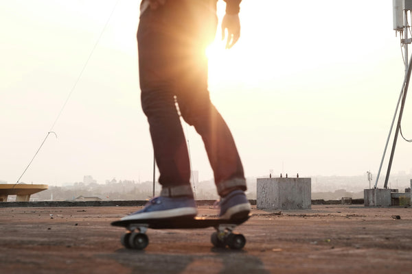 Skateboarder riding with sun setting background 