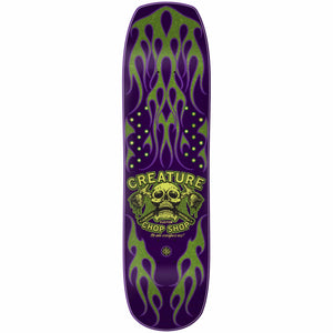 Skateboard deck with purple and green design featuring a skull and text on a white background