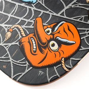 Skateboard deck with a cartoonish orange creature design on a spider web pattern.