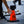 An orange independent traffic cone with a black base and a black smartphone mounted on top, 