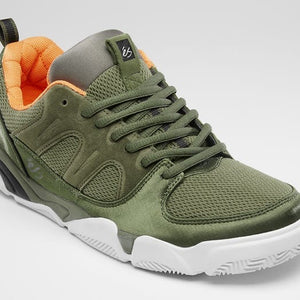 An olive green athletic sneaker with a white sole, featuring a textured mesh and suede upper, green laces, and a bright orange interior lining.
