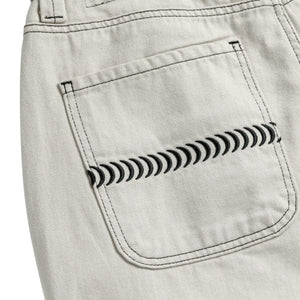 Flat lay of SPITFIRE natural denim pants with black thread accents