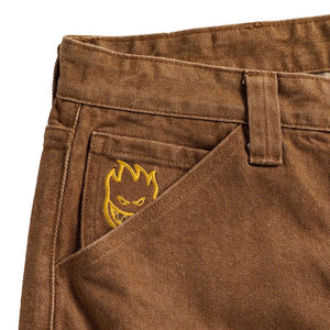 Close-up of Spitfire embroidered logo on brown washed denim fabric