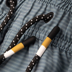 Black and yellow shoelace with white polka dots on storm  blue striped fabric no sweat shorts