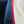 Close-up of a textile or leather material sample with three vertical sections: a dark navy fuzzy fabric, a dark blue textured fabric, and a light beige pebbled leather surface separated by a bright red stitched border.