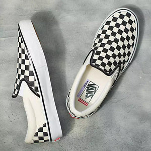 Black and white checkered slip-on sneaker on a grey background